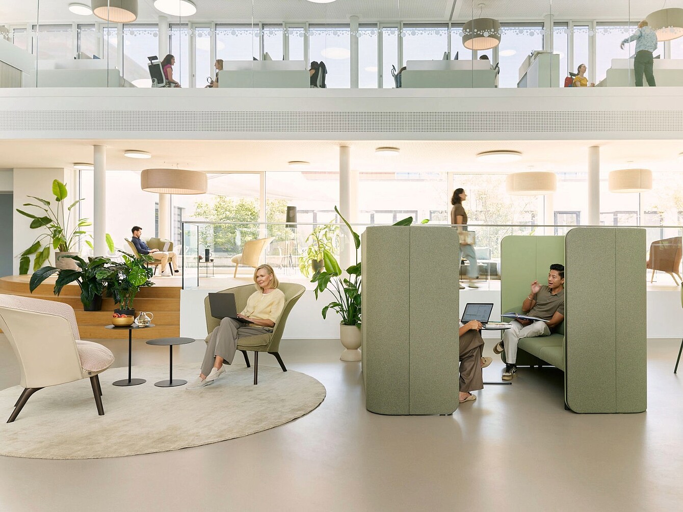 Moderne kantoorruimte met open zitplaatsen, akoestische cabines met hoge rugleuning en natuurlijk licht door grote ramen