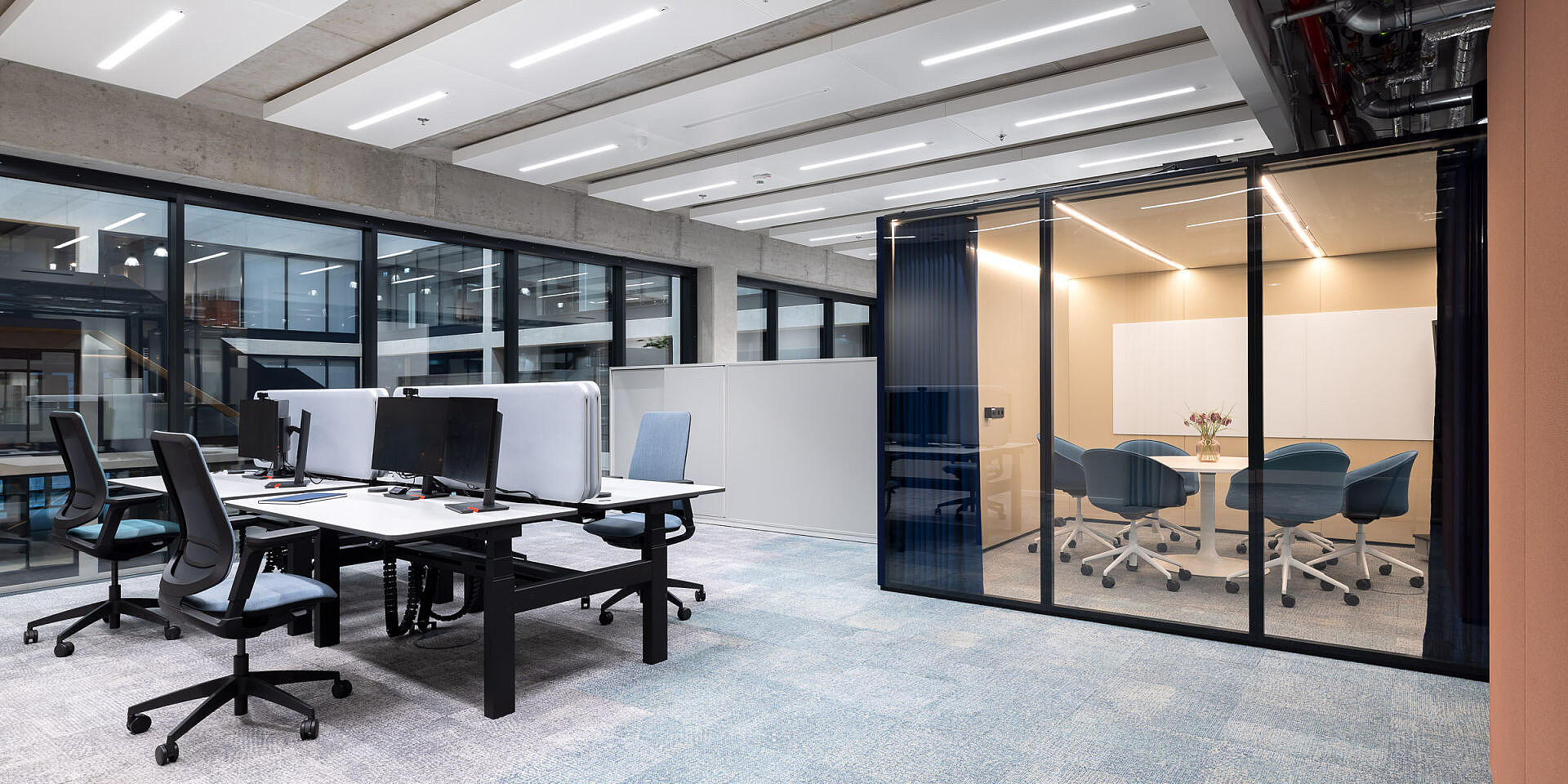 Modernos puestos de trabajo en equipo en Veolia con puestos de trabajo dobles regulables en altura «temptation smart twin» y sillas giratorias ergonómicas se:flex en una oficina luminosa y diáfana. 