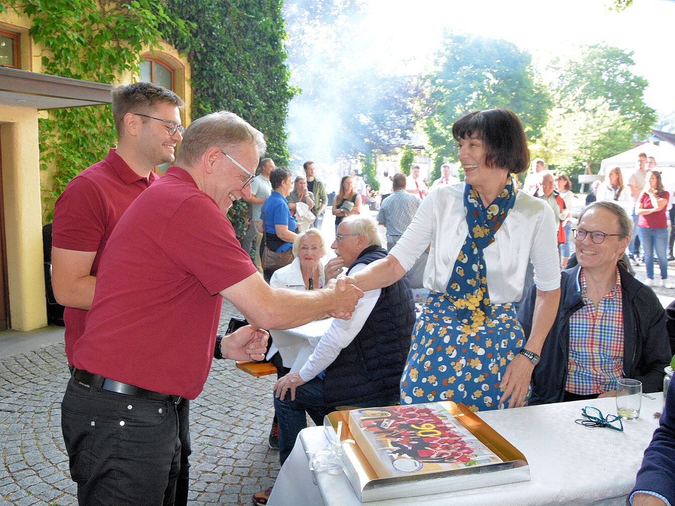 Adelheid Kummle überreicht bei Sedus Werksmusik Jubiläumskonzert eine Geburtstagstorte mit Foto der Werksmusik-Mitglieder an Herbert Ebner